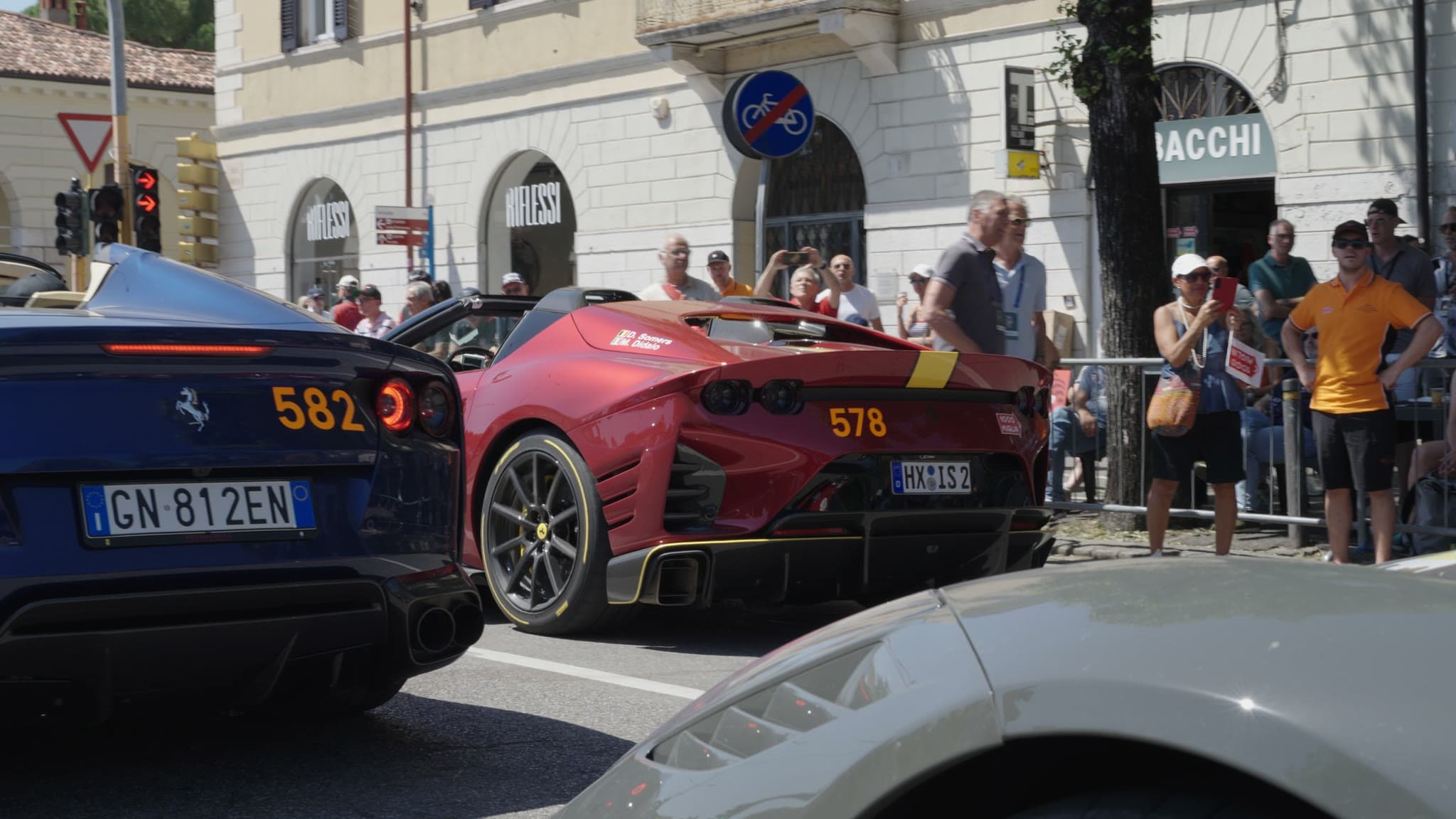 Sports cars lined up at a road rally in an Italian town