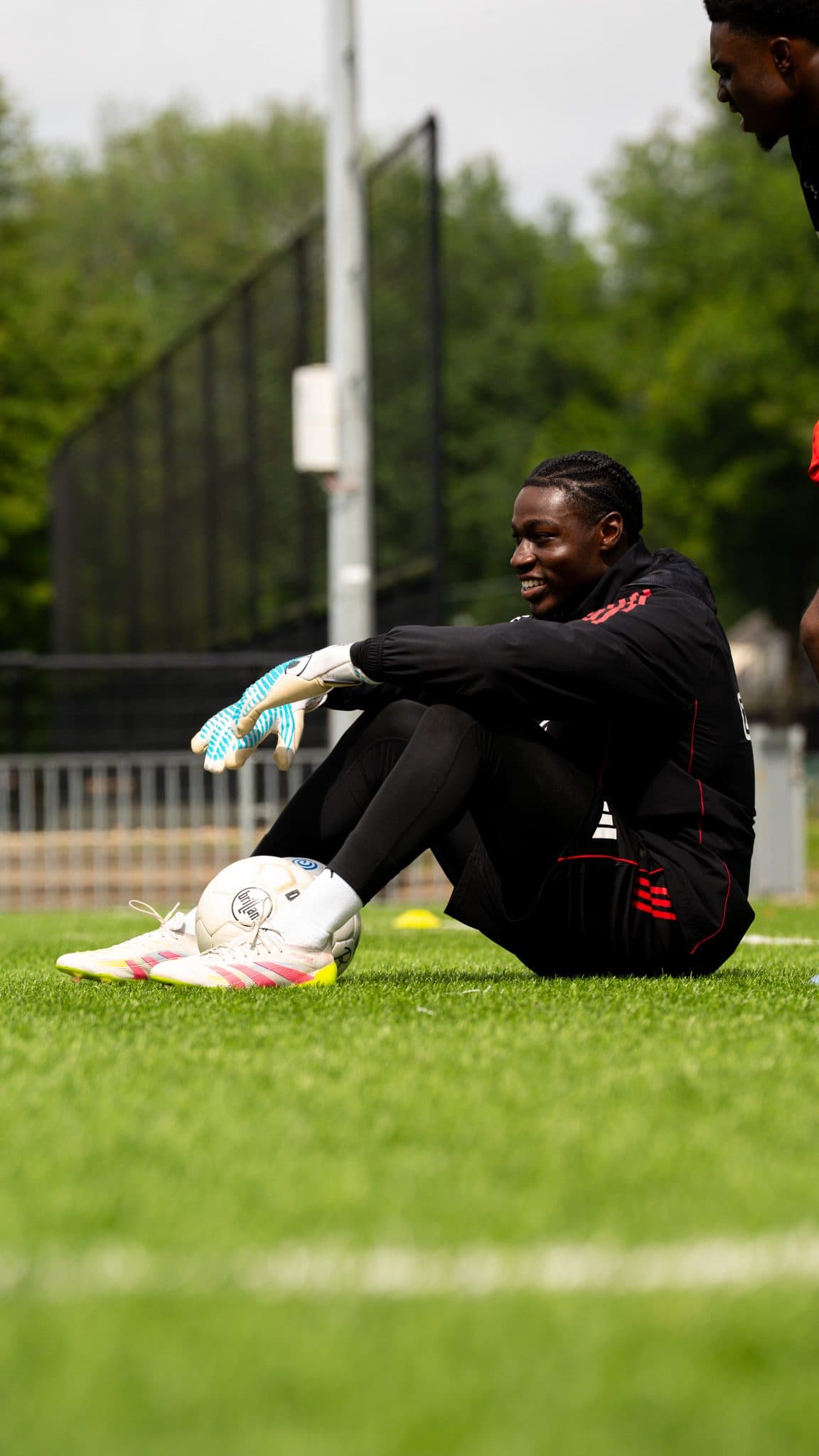 Goalkeeper sitting on the pitch with the ball