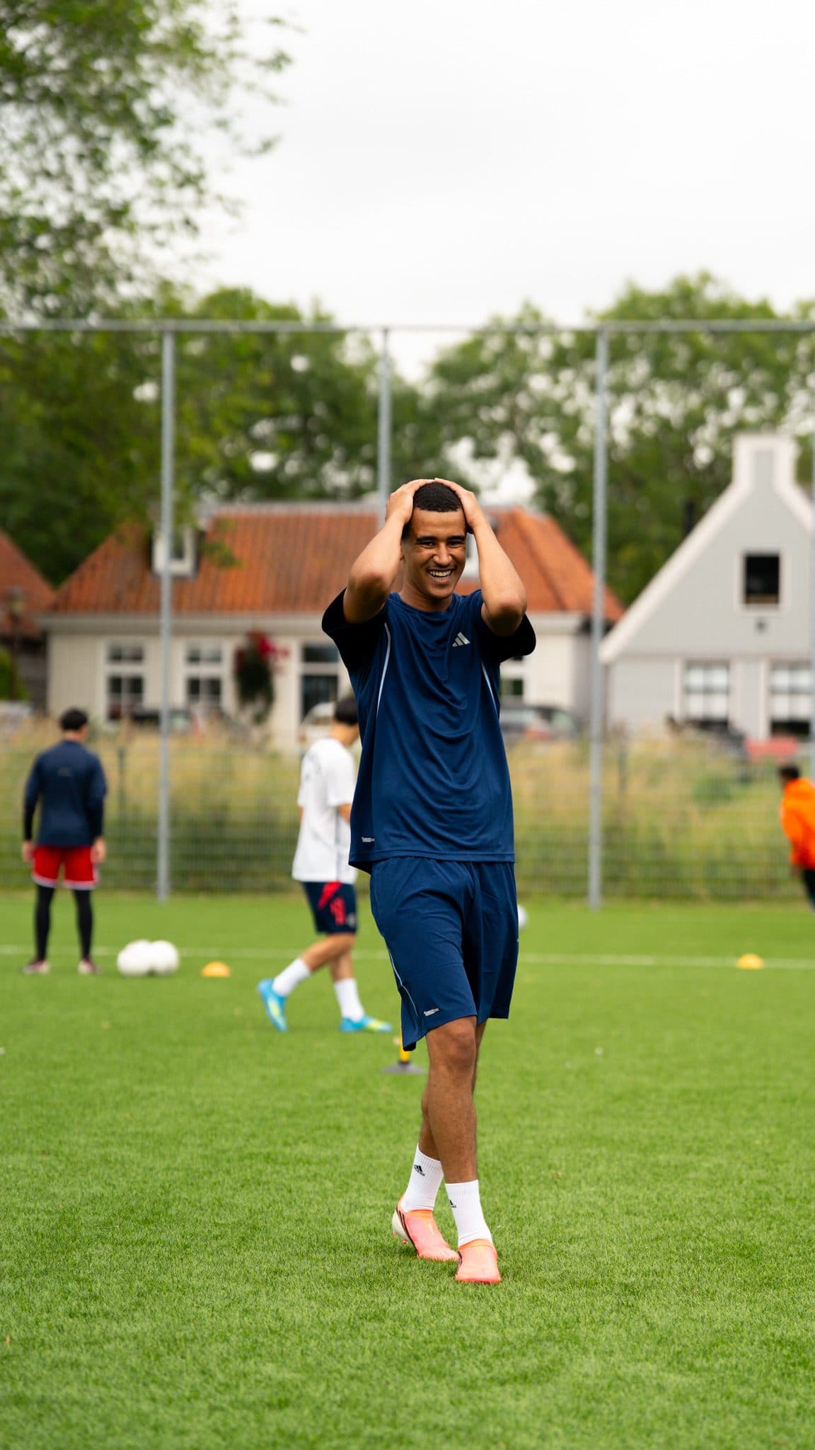 Player laughing with his hands on his head