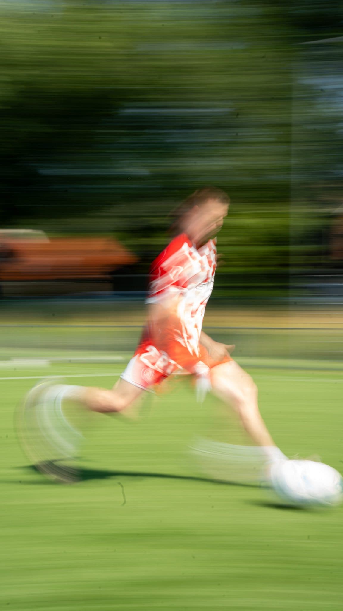 Motion-blurred player striking the ball